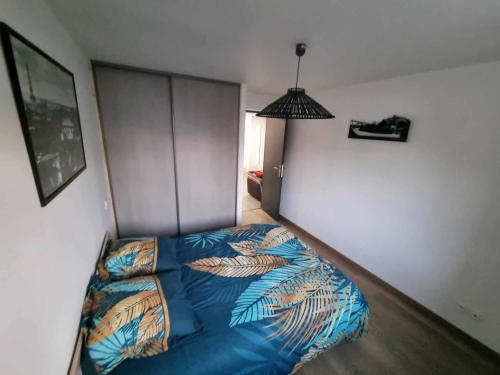 a bedroom with a bed with a blue comforter at Appartement le Crozatier in Saint-Georges