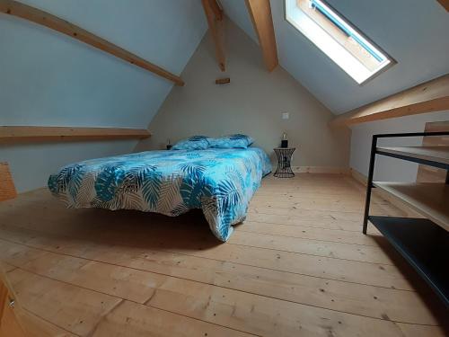 een slaapkamer met een bed op zolder bij Le petit chalet in Portbail