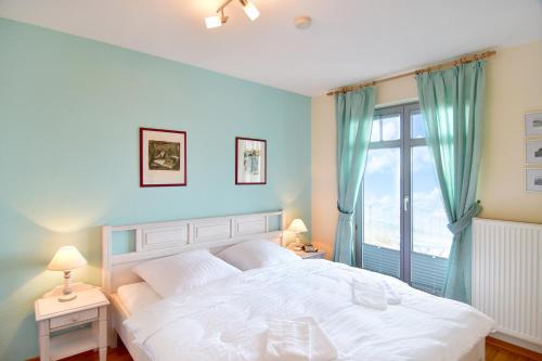 Un dormitorio con una gran cama blanca y una ventana en Haus-am-Kliff-App-07, en Heringsdorf