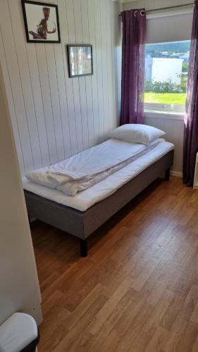 a bed in a room with a window at Lofoten Overnatting - Ballstad in Ballstad