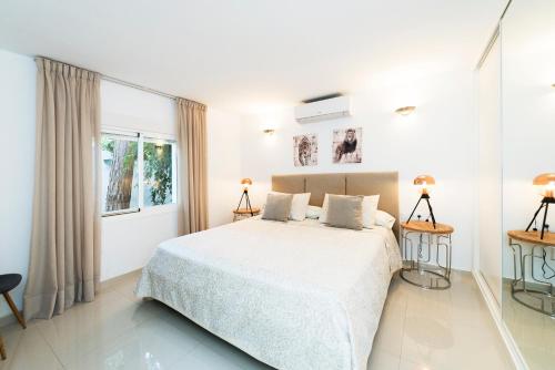 ein weißes Schlafzimmer mit einem Bett und einem Fenster in der Unterkunft VILLA SIEMPRE DOMINGO MARBELLA in Marbella
