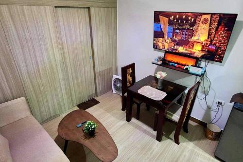 uma sala de estar com uma mesa e um quarto com um sofá em JustAnn Escape Staycation em Manilla