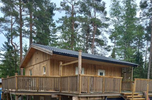 uma grande cabina de madeira com um grande deque em Easystar guest house em Enkärret