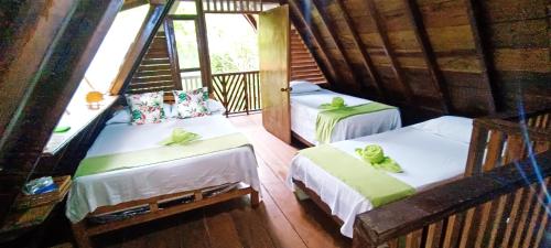 Habitación con 2 camas y escalera. en Hotel Ecologico Makalombia, en La Macarena
