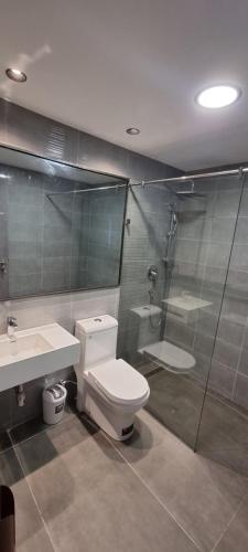 a bathroom with a toilet and a shower and a sink at Amal Suites in Accra