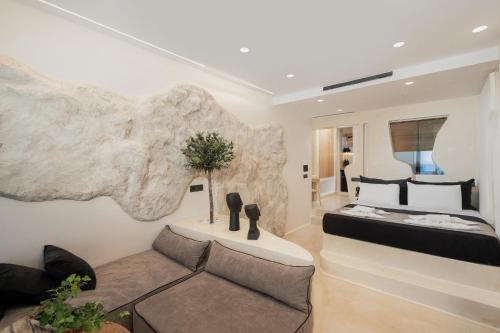 a bedroom with a bed and a couch at Portara Seaside Luxury Suites in Naxos Chora