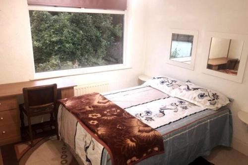 een slaapkamer met een bed, een bureau en een raam bij Budgeted Residence near Coventry Building Society (CBS) Arena with Parking in Exhall