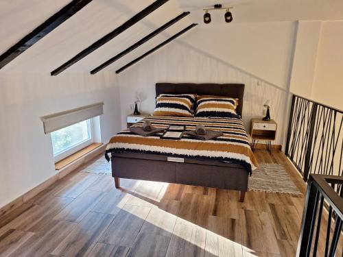 a bedroom with a large bed in a attic at Kuća za odmor Sweet Home in Vukovar