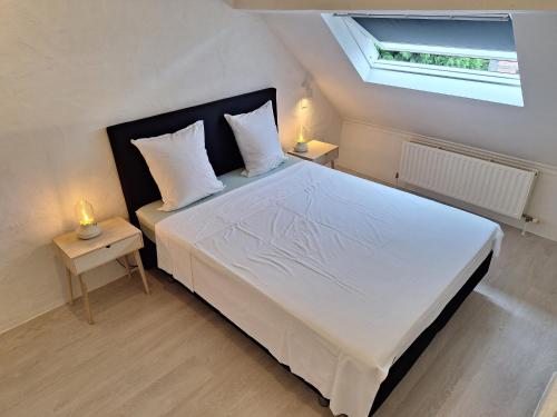 een slaapkamer met een groot wit bed en 2 nachtkastjes bij Huis ALNA 3 in Mechelen