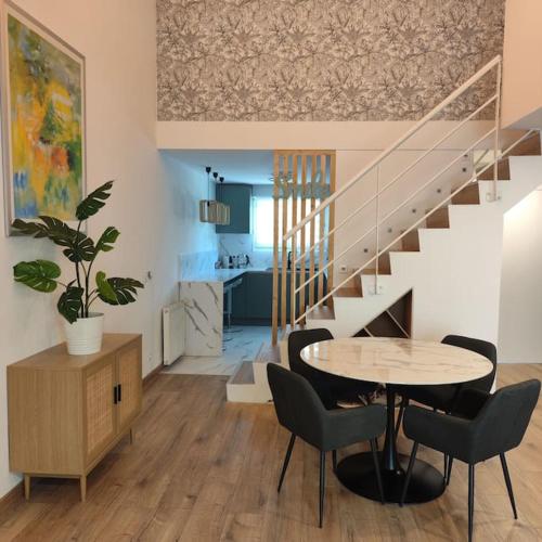 une salle à manger avec une table et des chaises et un escalier dans l'établissement Superbe Cosy Duplex Appartement T3 Charpenne Tête D'or avec parking privé gratuit, à Villeurbanne