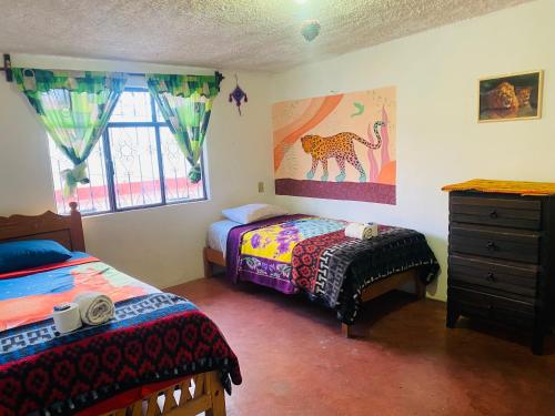 a bedroom with two beds and a dresser at Casa de los colores San cris in San Cristóbal de Las Casas