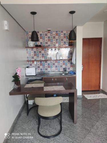 a kitchen with a wooden table and a counter top at FLAT FUNCIONAL e ECONÔMICO,CENTRO-GO in Goiânia