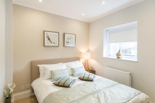 1 dormitorio con 1 cama con 2 almohadas en High Street Kensington Apartment, en Londres
