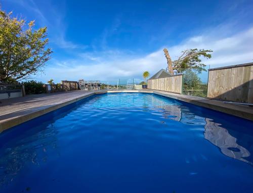 a swimming pool with blue water in a yard at Kauri Villas in Parua Bay