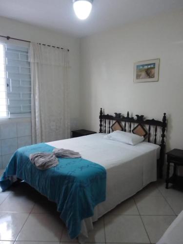 a bedroom with a bed with a blue blanket on it at Residêncial Rosa in Florianópolis