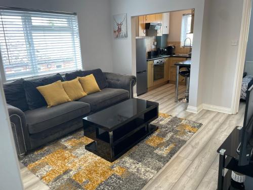 ein Wohnzimmer mit einem Sofa und einem Tisch in der Unterkunft Luxury 2 bedroom maisonette with private garden, fibre WIFI, Sky channels in Camberley