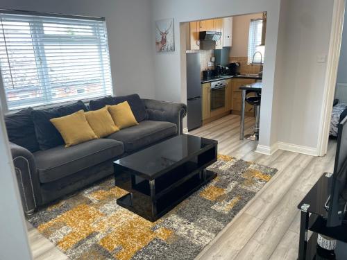 a living room with a couch and a table at Luxury 2 bedroom maisonette with private garden, fibre WIFI, Sky channels in Camberley