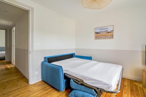 Cette chambre comprend un lit avec un cadre bleu. dans l'établissement Dans l’ancien Grand Hôtel T3 lumineux, à Houlgate