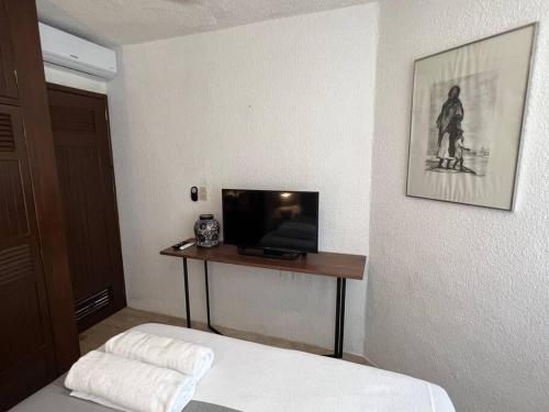 - une chambre avec un lit et une télévision sur une table dans l'établissement Amazing ocean front. 418, à Cancún
