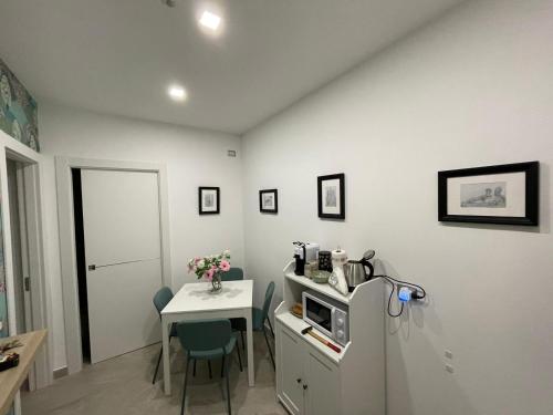 una piccola cucina con un piccolo tavolo e un frigorifero di Domus Cervantes Apartment a Napoli