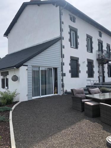 a white house with a patio in front of it at Burin des rosiers in Olby