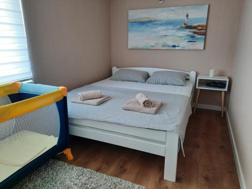 een kleine slaapkamer met een bed met handdoeken erop bij Dream Home Nis in Niš