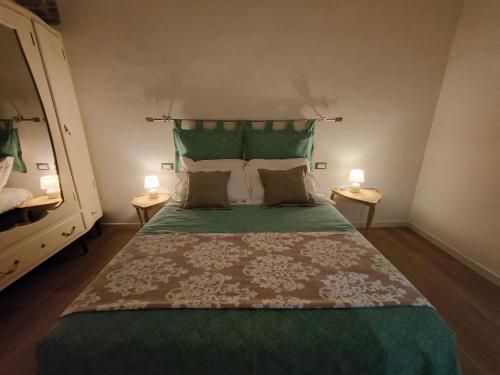 a bedroom with a large green bed with two lamps at Discover Donatello - Fiorenza in Florence