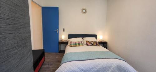 une chambre avec un lit avec deux lampes sur deux tables dans l'établissement LA PERLE DE LA PLAINE, à Marseille