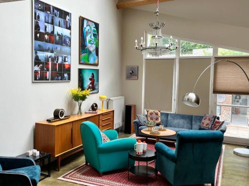 sala de estar con sillas azules y sofá en Ancien Cinema Loft, en Vianden
