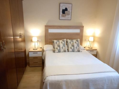 a bedroom with a bed with two lamps on both sides at Casa Anita in Luarca