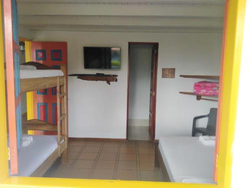 a room with bunk beds and a flat screen tv at Hosteria El Paraiso in Jardin