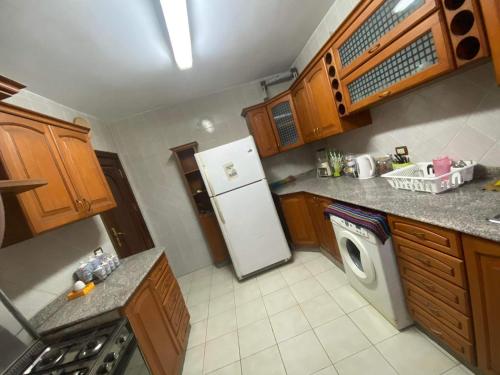 een keuken met een koelkast en een wasmachine bij شقة مفروشة بالمهندسين محيط نادي الصيد موقع متميز 3غرف نوم مكيفة بالكامل in Caïro
