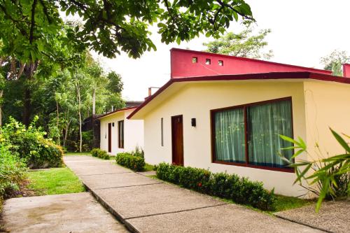 een klein wit huis met een rood dak bij Hotel Campestre Santa Clara in San Juan Bautista Tuxtepec