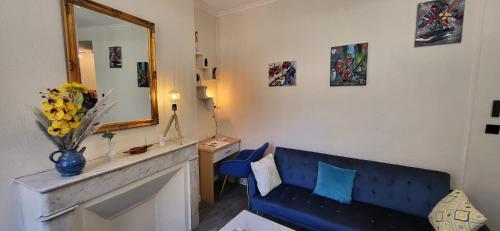 un salon avec un canapé bleu et un miroir dans l'établissement LA PERLE DE LA PLAINE, à Marseille