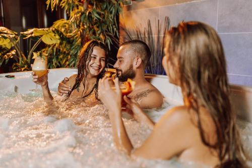 a group of people sitting in a bathtub at Hotel Kotarz Spa&Wellness in Brenna