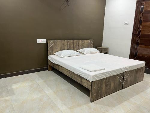 a bedroom with a large bed with a wooden headboard at SAN BEACH RESIDENCY in kāraikāl