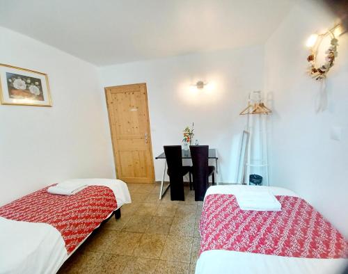 a room with two beds and a table in it at 3 private rooms shared flat in a villa at Sceaux 600m RER B direct to Notre-Dame in Sceaux
