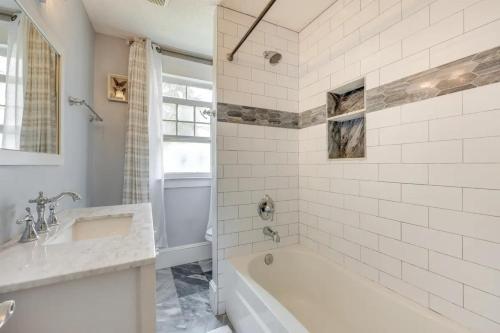 Baño blanco con bañera y lavamanos en Pet friendly home in Historic Springfield near TIAA en Jacksonville