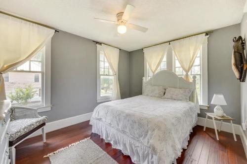 um quarto com uma cama, uma ventoinha de tecto e janelas em Pet friendly home in Historic Springfield near TIAA em Jacksonville