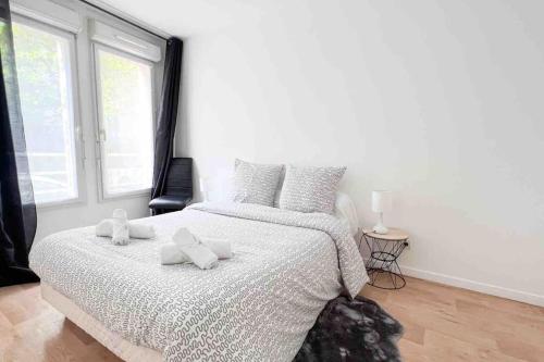 a white bedroom with a large bed with two white bows at Appart Pleyel familiale, St Denis, Paris, CGD in Saint-Denis