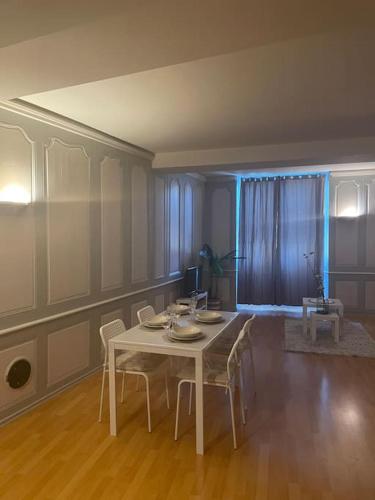 une salle à manger avec une table et des chaises blanches dans l'établissement « Au cœur de Dole », à Dole