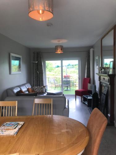 a living room with a table and a couch at Ballymacdoe Cottage Cushendall in Cushendall