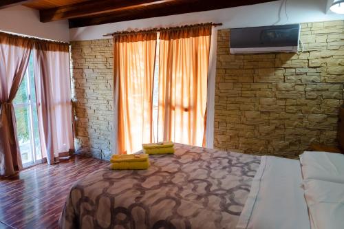 1 dormitorio con 1 cama grande y pared de piedra en Cabañas Ludmar en Potrero de los Funes