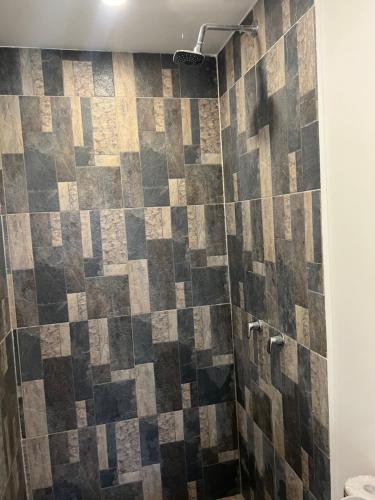 a bathroom with a shower with a tiled wall at occidente colonial santa fe de Antioquia tipo resort Aparta sol tobogán kanaloa parque acuático in Santa Fe de Antioquia