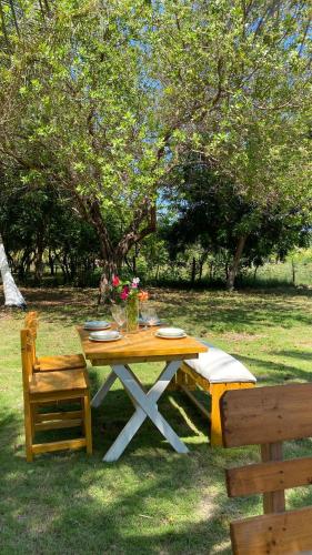 a picnic table with a bench and flowers on it at Villa Mediterránea in Tubará
