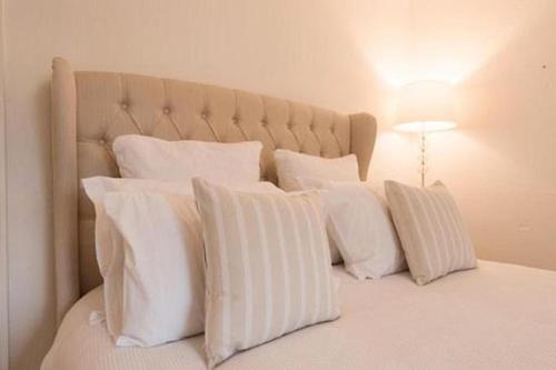 Una cama blanca con almohadas blancas. en The Blackwater Suite en Colchester