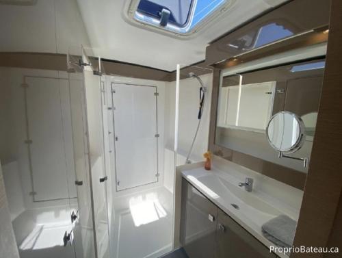 a bathroom with a sink and a mirror at Placencia Sailing Catamaran Day Charter « Gingembre » in Placencia