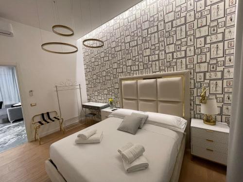 a bedroom with a large white bed with two towels at Maison 31 -Luxury Apartments in Santa Marinella