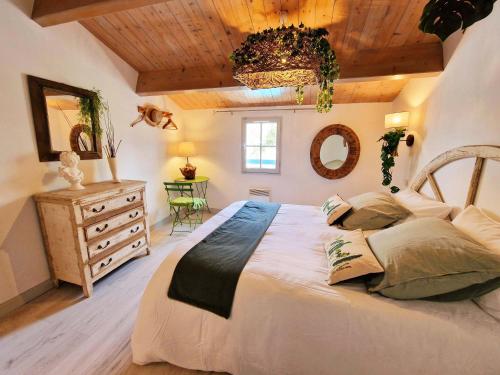 ein Schlafzimmer mit einem großen Bett und einer Holzdecke in der Unterkunft Les pieds dans l'eau: KER LILI (chez Liza) in Port-Joinville