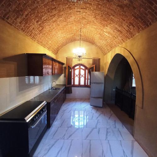 Mystical habou domes villa في الأقصر: مطبخ مع ممر وجدار من الطوب